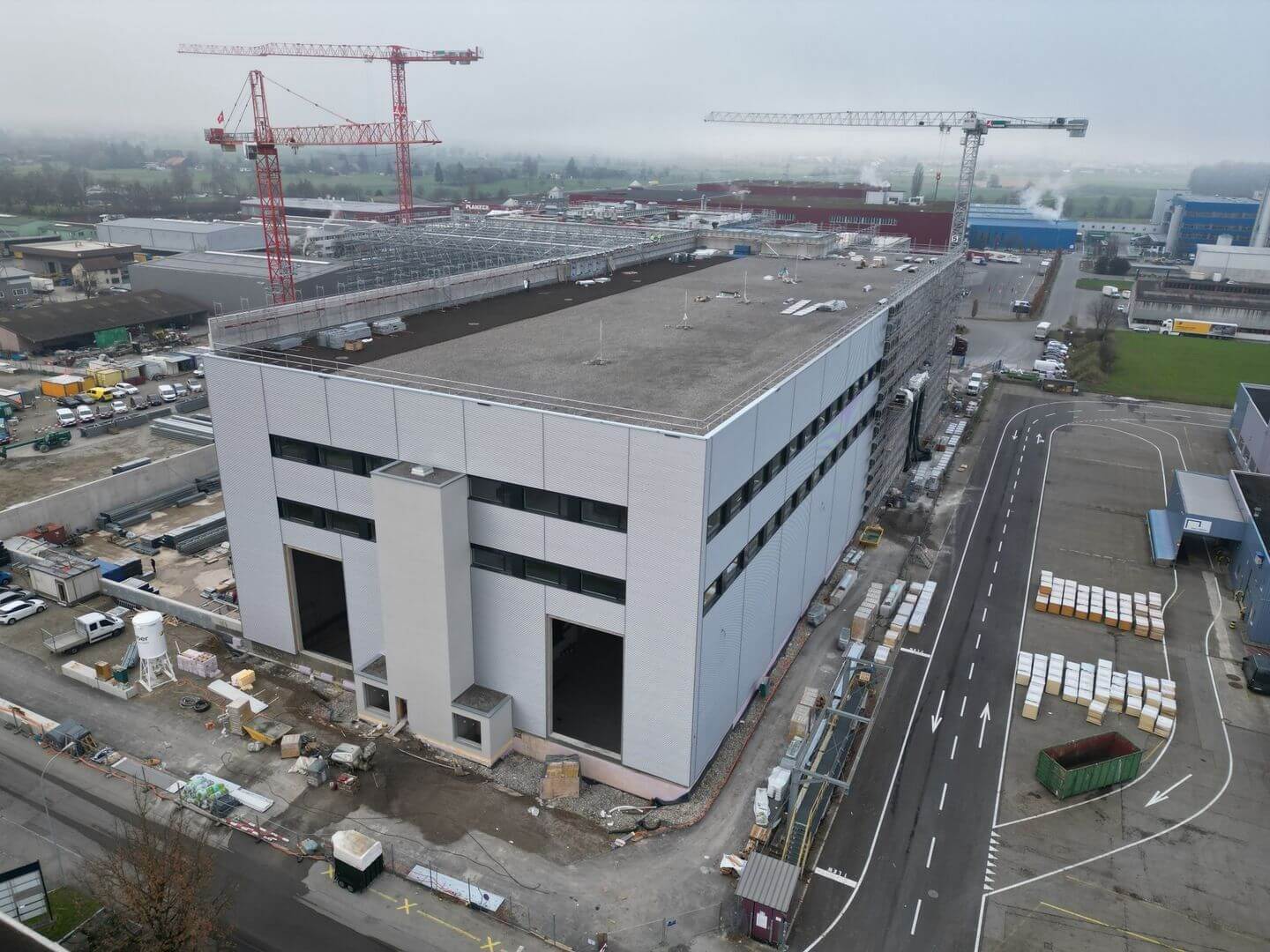 Luftaufnahme eines neuen Bau-Projekts an der Allmendstrasse, Villmergen, mit grossen Industriekränen.