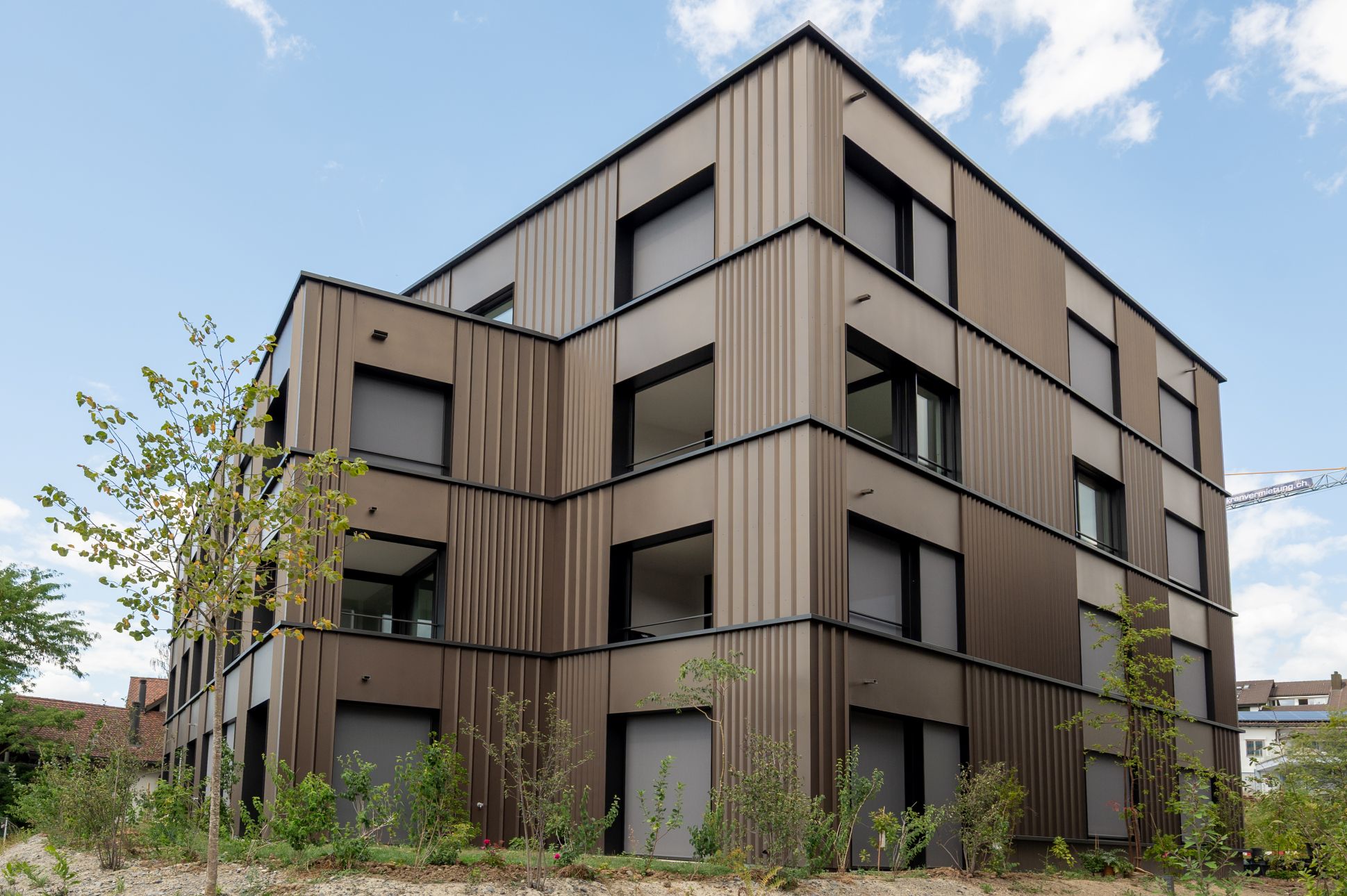 Mehrfamilienhaus in Baar mit nachhaltiger Metallfassade und moderner Fassadenarchitektur.
